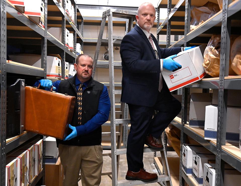 Abilene Police Department detectives Jeff Cowan (left) and Shawn Montgomery stand in the evidence room for murders at department headquarters Feb. 15.