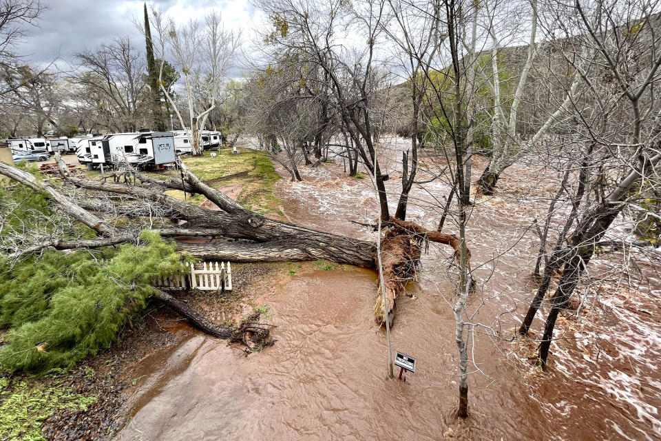 A creek running alongside an RV park rises with heavy rain and runoff Wednesday, March 22, 2023, near Cornville, Ariz. Several water rescues were reported across central and northern Arizona on Wednesday. (Vyto Starinskas/The Daily Courier via AP)