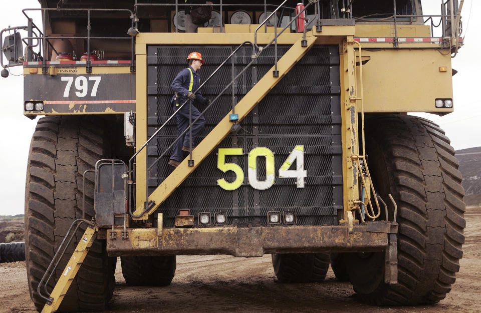 Michelle Noer climbs the steps to the world's largest dump truck at the Syncrude Aurora mine near Fort McMurray, Alberta, in this May 23, 2006 file photo. The oil boom has also brought pitfalls to Canada's oil town of Fort McMurray that now has 61,000 residents, up from 34,000 just 10 years ago. Another 9,000 live in work camps that support massive construction projects. There are an estimated 450 homeless, as would-be workers struggle to find a home, and police have doubled their drugs squad -- to six from three -- to cope with rising crime. To match feature Canada Boomtown.  REUTERS/Todd Korol/Files