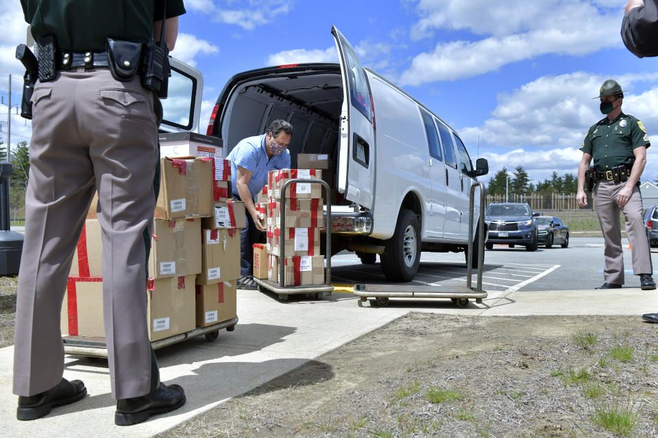 FILE - In this May 11, 2021 file photo, a clerk with the New Hampshire Department of State unloads boxes of ballots, in Pembroke, N.H., for a forensic audit of a New Hampshire legislative election. Auditors concluded in a report released Tuesday, July 13, 2021, that miscounts in a New Hampshire election were caused by the way ballots were folded. (AP Photo/Josh Reynolds, File)