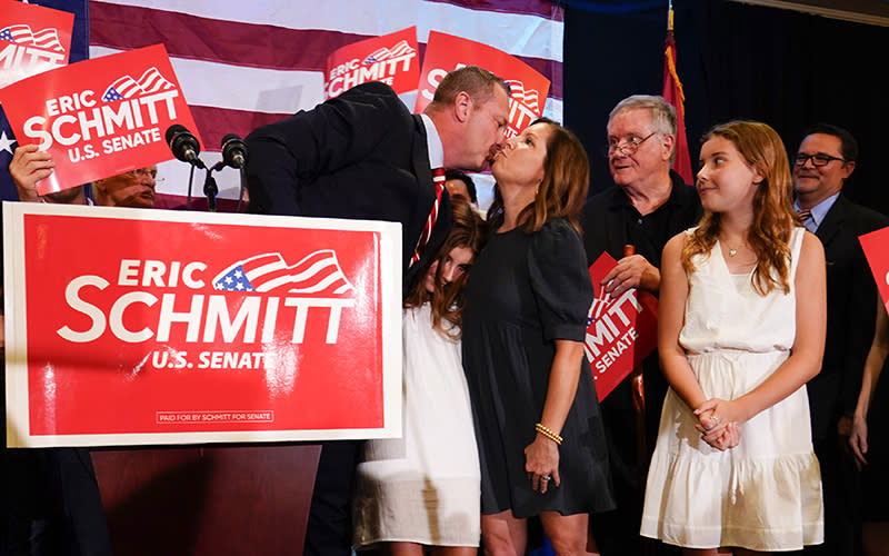 Eric Schmitt acknowledges his wife, Jaime Schmitt, and their children on stage at an election night