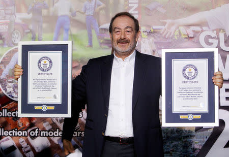 Nabil Karam poses with his Guinness World Record certificates for the largest collection of model cars and the largest collection of dioramas, in celebration of the Guinness World Records Day in Zouk Mosbeh, north of Beirut, Lebanon November 16, 2016. REUTERS/Aziz Taher