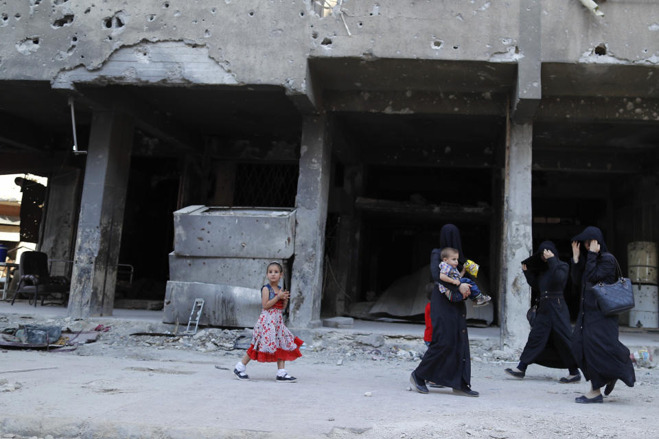 In this July 15, 2018 photo, Syrian women walk in Douma, near the Syrian capital Damascus, Syria. The fate of activist Razan Zaitouneh is one of the longest-running mysteries of Syria’s civil war. There’s been no sign of life, no proof of death since gunmen abducted her and three of her colleagues from her offices in the rebel-held town of Douma in 2013. Now Douma is in government hands and clues have emerged that may bring answers. (AP Photo/Hassan Ammar)
