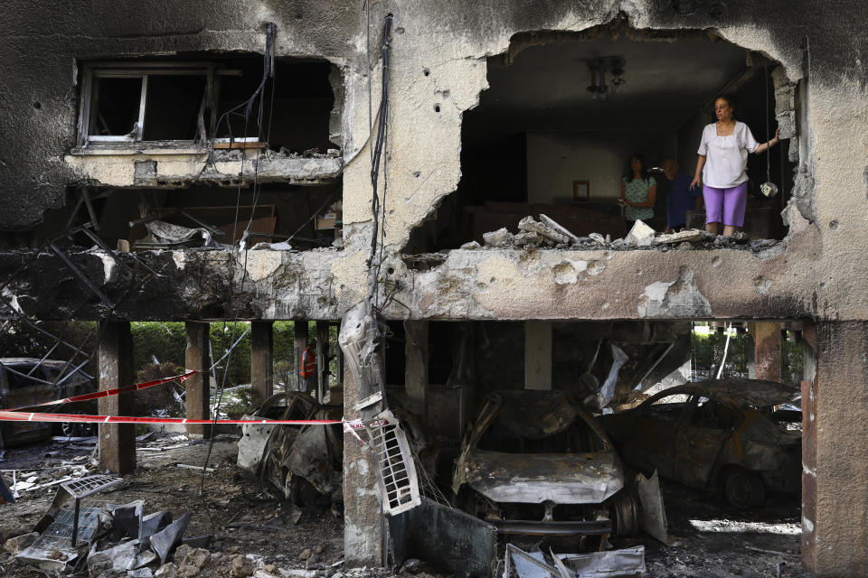 Miembros de la familia Sror revisan lo daños en su apartamento tras el impacto de un cohete lanzado desde la Franja de Gaza durante la noche en la localidad de Petah Tikva, en el centro de Israel, el jueves 13 de mayo de 2021. (AP Foto/Oded Balilty)