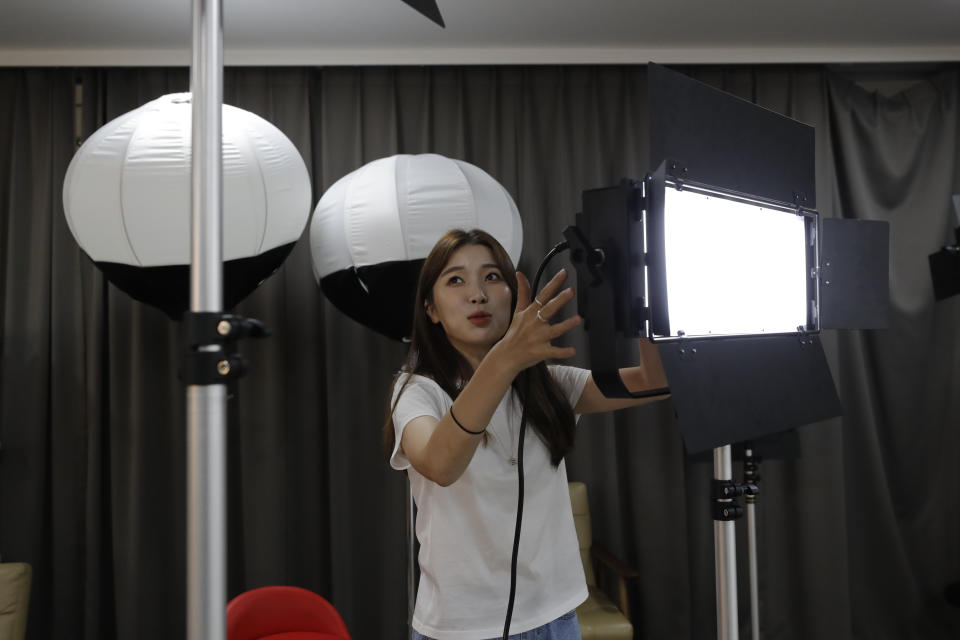 In this Sept. 5, 2019, photo, Kang Na-ra, 22, adjusts a lighting as she prepares to a YouTube program at a studio in Seoul, South Korea. In South Korea, a handful of young North Korean refugees have launched YouTube channels in recent years to offer a rare glimpse into life in the North. Kang, a North Korean escapee who regularly appears on two YouTube channels and two TV programs, is called “Princess Na-ra” by her fans. (AP Photo/Lee Jin-man)