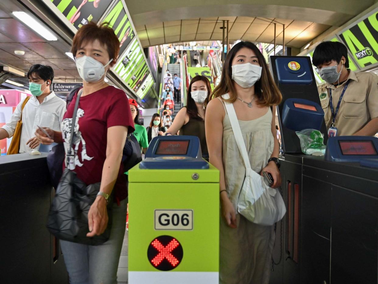 People wear protective facemasks at a commuter train station in Bangkok, Thailand, on 28 January, 2020: AFP via Getty Images