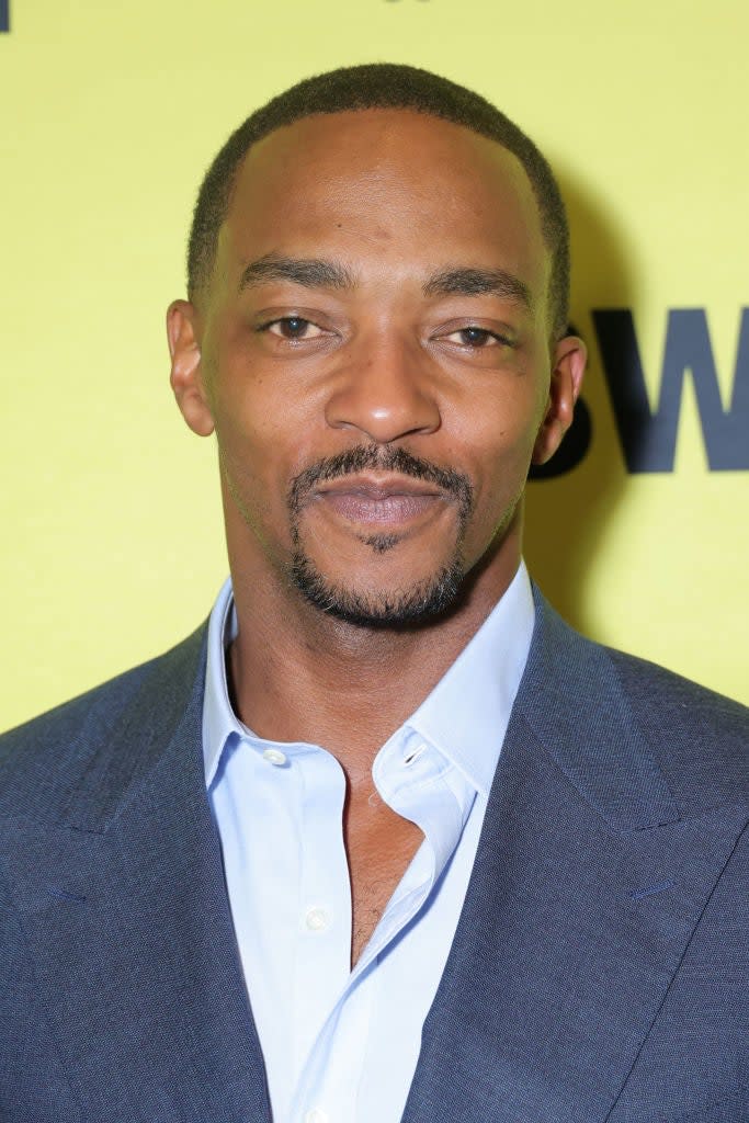 Actor Anthony Mackie at an event, wearing a tailored blue suit and light blue shirt