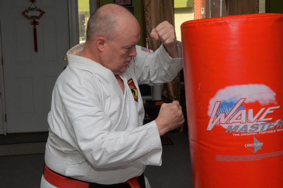 Sensei David Harris demonstrates a karate punching technique during a training session last week at the New Bern School of Martial Arts.