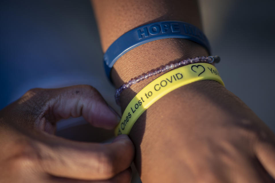 Melanese Marr-Thomas wears rubber bracelets in support of those who have lost a loved one to COVID, like herself who lost her husband, Charles Thomas, in District Heights, Md., on Wednesday, Sept. 21, 2022. “I still relive that night,” Melanese says. “I was so numb and in disbelief that someone that was just talking to me is no longer here. He was the pillar of our family, the foundation, our protector. He was everything and it is an immeasurable loss.” (AP Photo/Wong Maye-E)