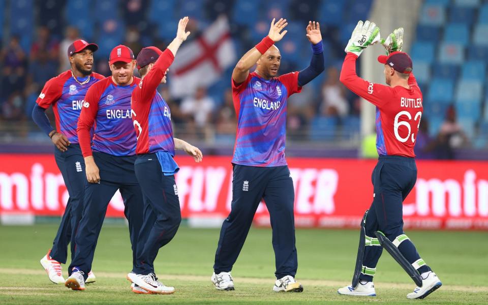 Tymal Mills of England celebrates the wicket of Nicholas Pooran of West Indies with team mate Jos Buttler during the ICC Men's T20 World Cup match between England and Windies at Dubai International Stadium on October 23, 2021 in Dubai, United Arab Emirates. - GETTY IMAGES