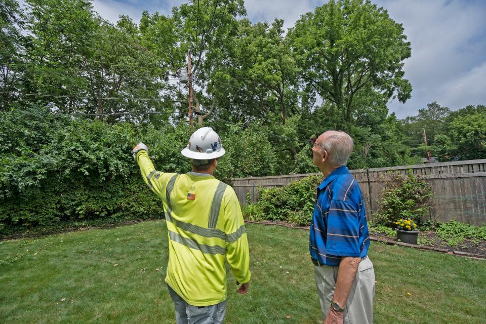 Bill Conlin talks to a Meade employee about work behind his home Monday, July 3, 2023.  Meade (out of Chicago) and Wright Tree Service work on areas without power on Camelback Drive and the area behind the Conlin home. The companies are contracted by AES.