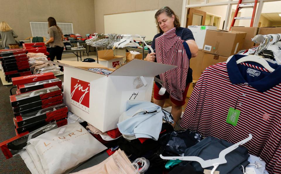 Susan Johnston prepares clothing for display as volunteers at the Rise Center in Tuscaloosa prepare for the Buy For Rise sale event in this 2019 file photo. [Staff Photo/Gary Cosby Jr.]