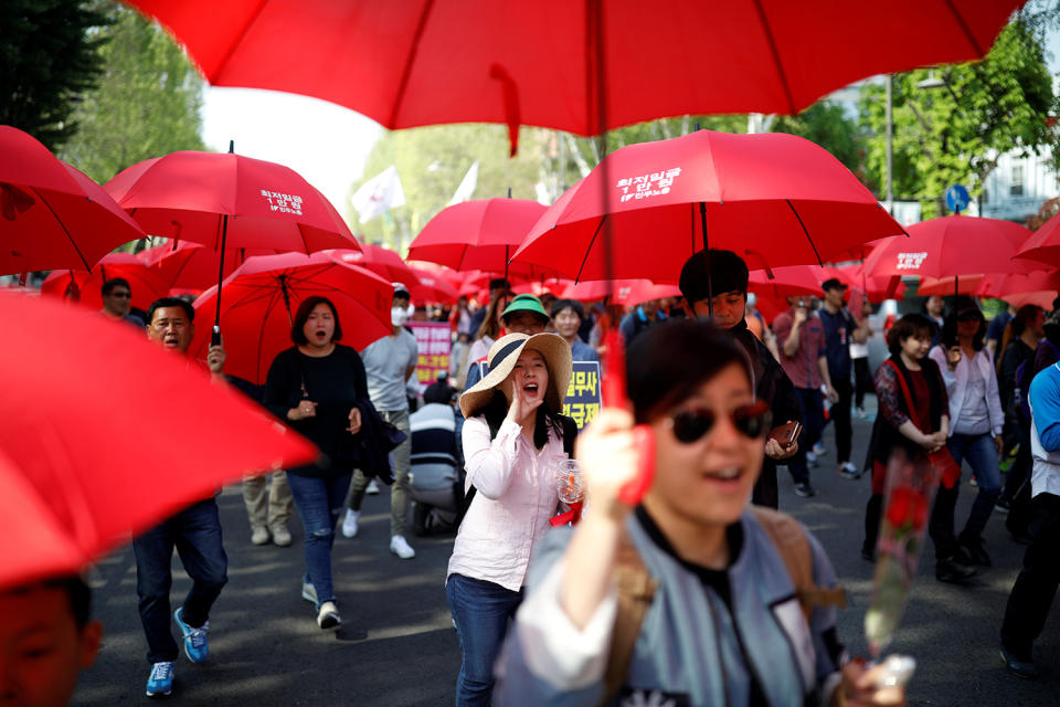 Union workers holding red umbrellas