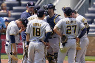 Milwaukee Brewers pitching coach Chris Hook, left rear, talks with pitcher Freddy Peralta during a meeting on the mound in the sixth inning of a baseball game against the Pittsburgh Pirates in Pittsburgh, Sunday, July 4, 2021. (AP Photo/Gene J. Puskar)