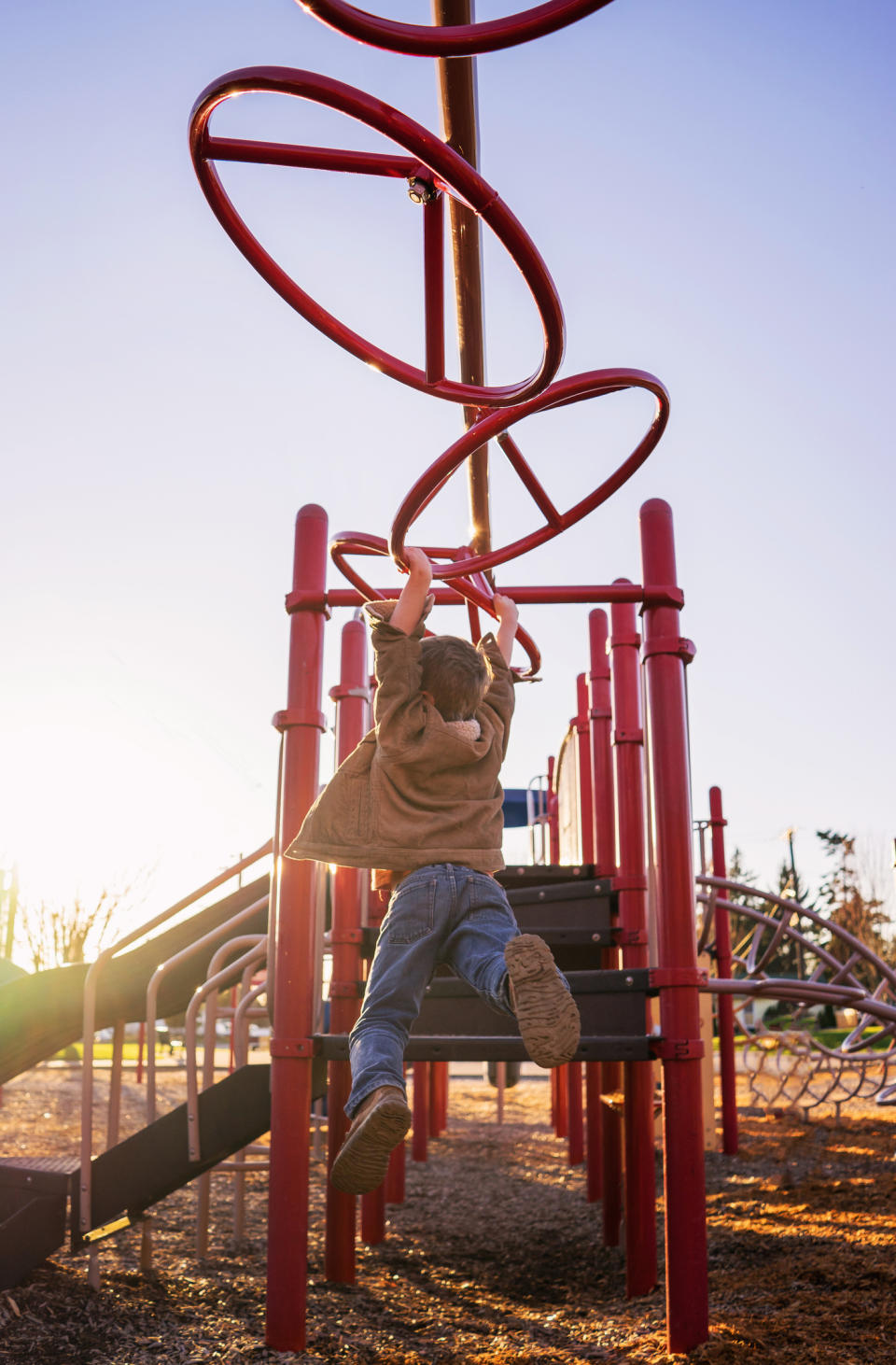 A kid swinging on monkey bars