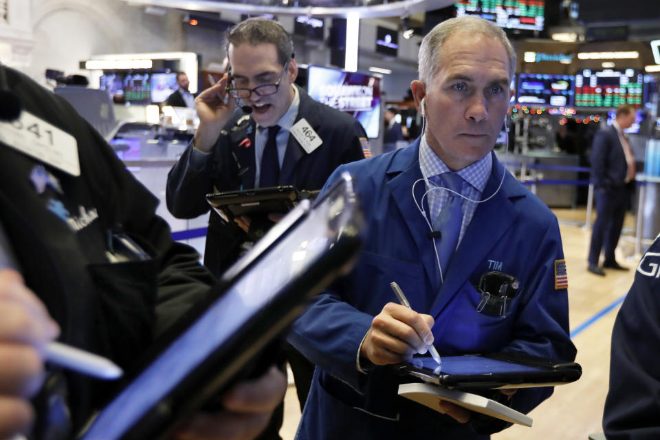 FILE- In this Jan. 3, 2019, file photo Timothy Nick, right, works with fellow traders on the floor of the New York Stock Exchange. The U.S. stock market opens at 9:30 a.m. EST on Tuesday, Jan. 8. (AP Photo/Richard Drew)