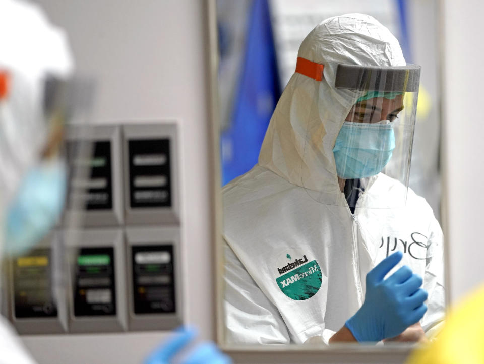 Medical student Bryan Delgado puts on PPE inside the Coronavirus Unit at United Memorial Medical Center, Monday, July 6, 2020, in Houston. Anyone seeing a COVID-19 patient is required to wear two sets of masks, gowns, gloves, shoe and head coverings, and a face shield. (AP Photo/David J. Phillip)