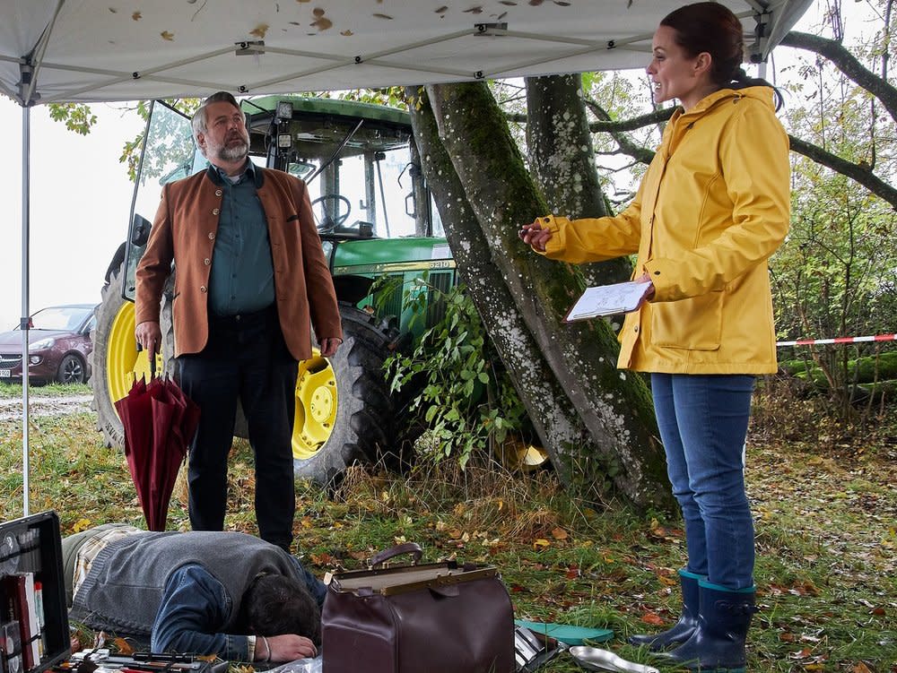 "Die Rosenheim-Cops - Bauer sucht Bauer": Pathologin Mai (Sina Wilke, r.) erläutert den Kommissaren Stadler (Dieter Fischer, l.) und Winter (Vanessa Eckart, nicht im Bild), dass das Opfer aus der Ferne erschossen wurde. (Bild: ZDF / Bojan Ritan)