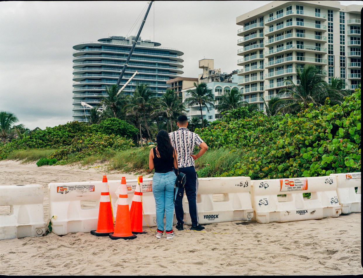 People look at the collapsed Champlain Towers South building from afar on Miami Beach in Surfside, Fla. on June 30, 2021.