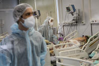 Medical staff in special suits treat a COVID-19 patient at an ICU in Infectious Hospital No. 23 in Nizhny Novgorod, Russia, on Wednesday, Oct. 20, 2021. Russians’ hesitancy in getting the vaccine is of increasing concern as the country suffers a sharp rise in cases, setting records for infections and deaths nearly every day this month. (AP Photo/Roman Yarovitcyn)