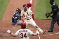 St. Louis Cardinals' Austin Dean (0) celebrates after scoring past Milwaukee Brewers catcher Omar Narvaez as Cardinals' John Nogowski (34) cheers during the sixth inning of a baseball game Saturday, April 10, 2021, in St. Louis. (AP Photo/Jeff Roberson)