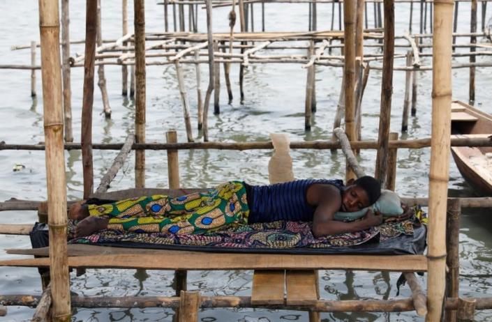 A man sleeps on wooden stilts built on a lagoon in the Makoko fishing community in Nigeria&quot;s commercial capital Lagos February 26, 2022. Picture taken February 26, 2022.