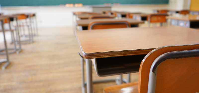 Desks are seen in a classroom