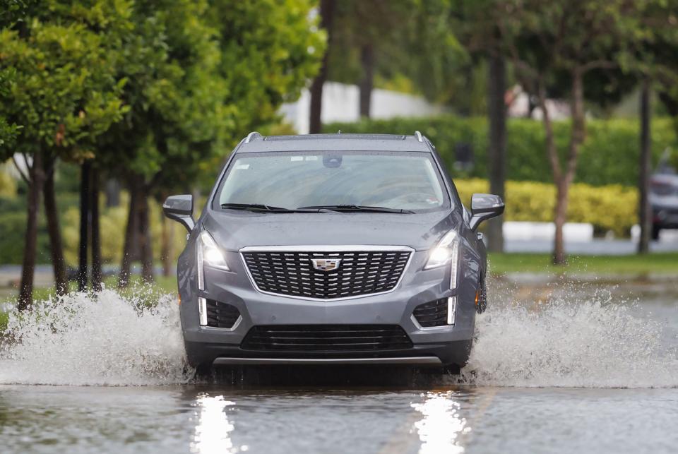 A car goes through the flooded road cause by heavy rains at North Bay Rd. in Sunny Isles Beach, Fla., Wednesday, April 12, 2023. A torrential storm bought heavy showers, gusty winds and thunderstorms to South Florida on Wednesday and prompted the closure of Fort Lauderdale-Hollywood International Airport and the suspension of high-speed commuter rail service in the region.(David Santiago/Miami Herald via AP)