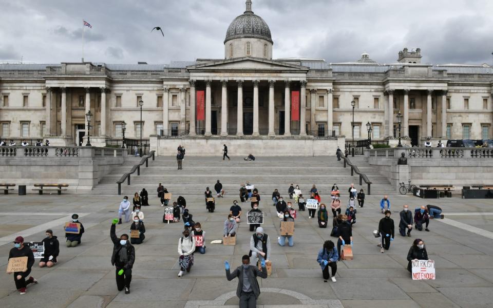 Protesters employing social distancing "take a knee" as they attend a demonstration in Trafalgar Square in central London on June 5, 2020, to show solidarity with the Black Lives Matter movement in the wake of the killing of George Floyd  - Dominic Lipinski/PA