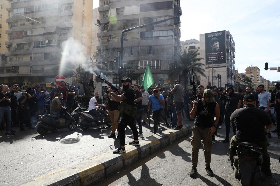 Supporters of the Shiite Amal group fire weapons in the air during the funeral processions of Hassan Jamil Nehmeh, who was killed during yesterday clashes, in the southern Beirut suburb of Dahiyeh, Lebanon, Friday, Oct. 15, 2021. Dozens of gunmen opened fire in the air Friday south of Beirut during the funeral of persons killed in hours of gun battles between heavily armed gunmen the day before that left several people dead and terrorized the residents of Beirut. (AP Photo/Bilal Hussein)