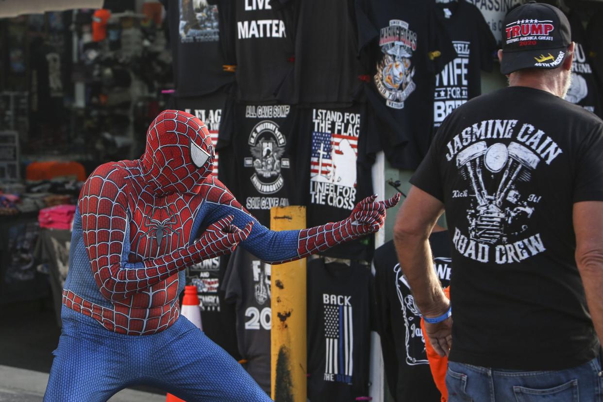 A man dressed as Spider-Man poses as people walk along Main Street in Daytona, FL during Bike Week on March 5, 2021. (Sam Thomas/Orlando Sentinel)