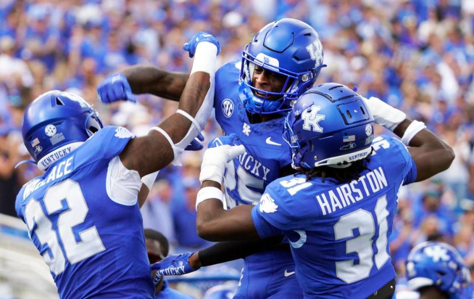 Defensive backs Jordan Lovett (25) and Maxwell Hairston (31) celebrate with linebacker Trevin Wallace (32) after his interception against Florida at Kroger Field on Sept. 30.