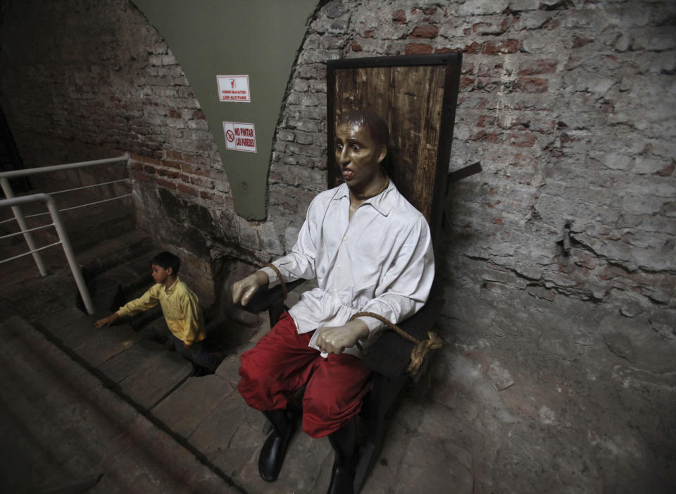 FILE - This May 18, 2010 file photo shows a child next aside a figure of a tortured man at the Spanish Inquisition museum in Lima. All museums in Peru celebrate the International Museum day by allowing free visitors throughout the day. There are plenty of things to do and see around Lima for free, from parks to plazas, and museums, like the Spanish Inquisition museum. (AP Photo/Martin Mejia)