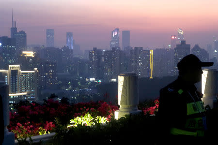 A security personnel stands guard at a viewing platform overlooking the central business area ahead of the 40th anniversary of China's reform and opening up in Shenzhen, Guangdong province, China December 4, 2018. REUTERS/Thomas Suen