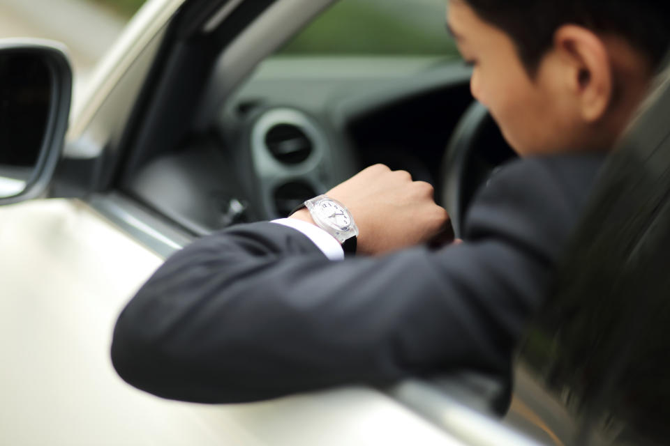 a person in the driver's seat looking at his watch