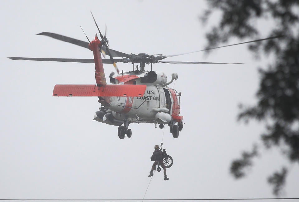 A Coast Guard helicopter hoists a wheel chair on board after lifting a person to safety in Houston.&nbsp;