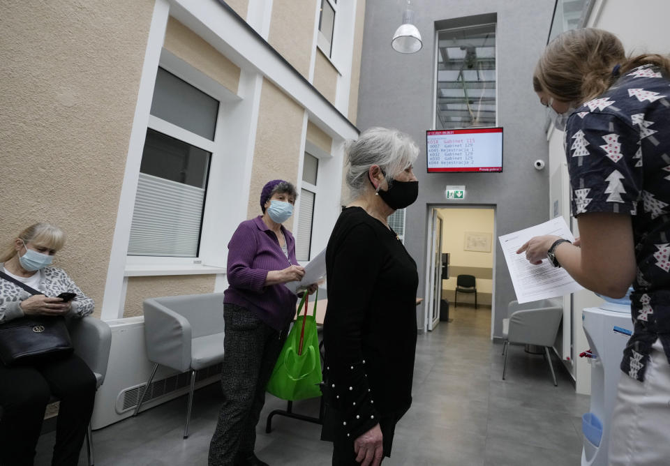 Hanna Zientara, an 83-year-old resident of Warsaw, receives a vaccination certificate after receiving a booster shot against COVID-19, in Warsaw, Poland, Tuesday Dec. 7, 2021. Poland and several other countries across central and eastern Europe are battling a massive surge of infection and death fueled by the transmissible delta variant. Now they face the specter of the another variant, omicron, with vaccinations rates far lower in the Western Europe. (AP Photo/Czarek Sokolowski)