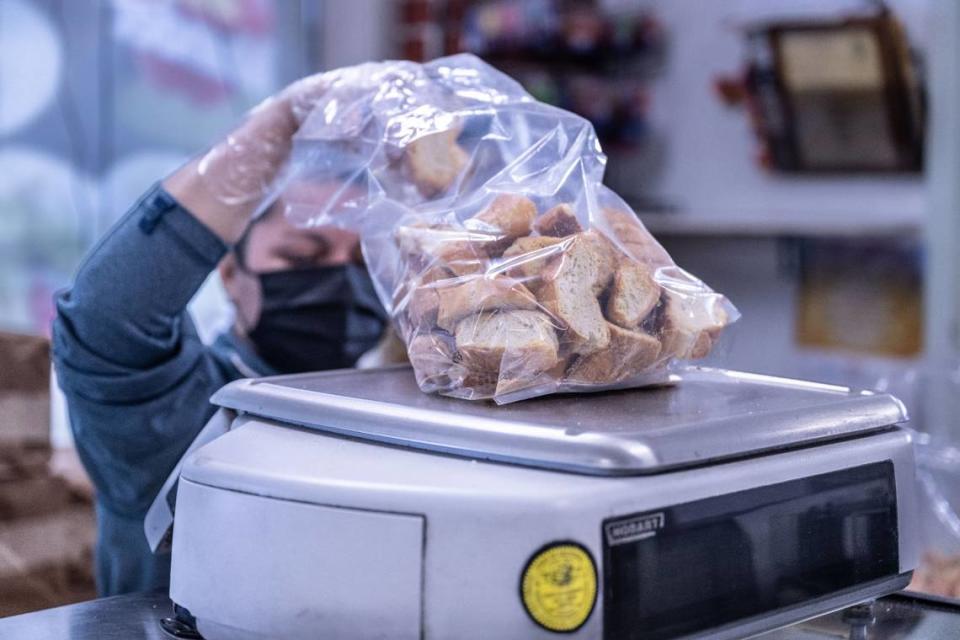 An employee at La Esperanza Bakery on Franklin Boulevard weighs cut bread on Tuesday, Feb. 13, 2024. The bread is used for a traditional Mexican bread pudding called capirotada, popular during the Lenten season.