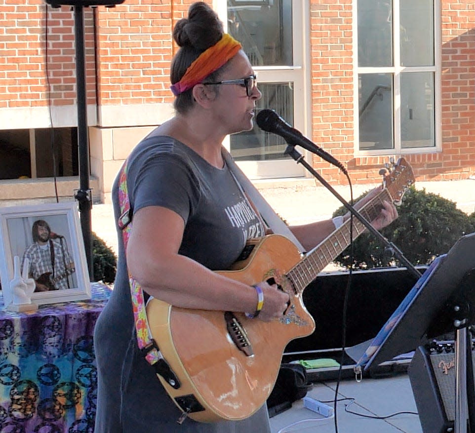 Lisa Gordon plays her late son's guitar while singing a tribute to him during the Overdose Awareness Day event Aug. 31 in downtown Granville.