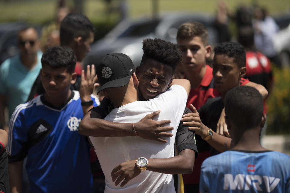 Friends grieve during the funeral of the young soccer player Arthur Vinicius, one of the victims of a fire at a Brazilian soccer academy, in Volta Redonda, Brazil, Saturday, Feb. 9, 2019. A fire early Friday swept through the sleeping quarters of an academy for Brazil's popular professional soccer club Flamengo, killing several and injuring others, most likely teenage players, authorities said. (AP Photo/Leo Correa)