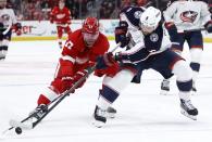 Detroit Red Wings right wing Daniel Sprong (17) tries to steal the puck from Columbus Blue Jackets defenseman Ivan Provorov (9) during the first period of an NHL hockey game Tuesday, March 19, 2024, in Detroit. (AP Photo/Duane Burleson)