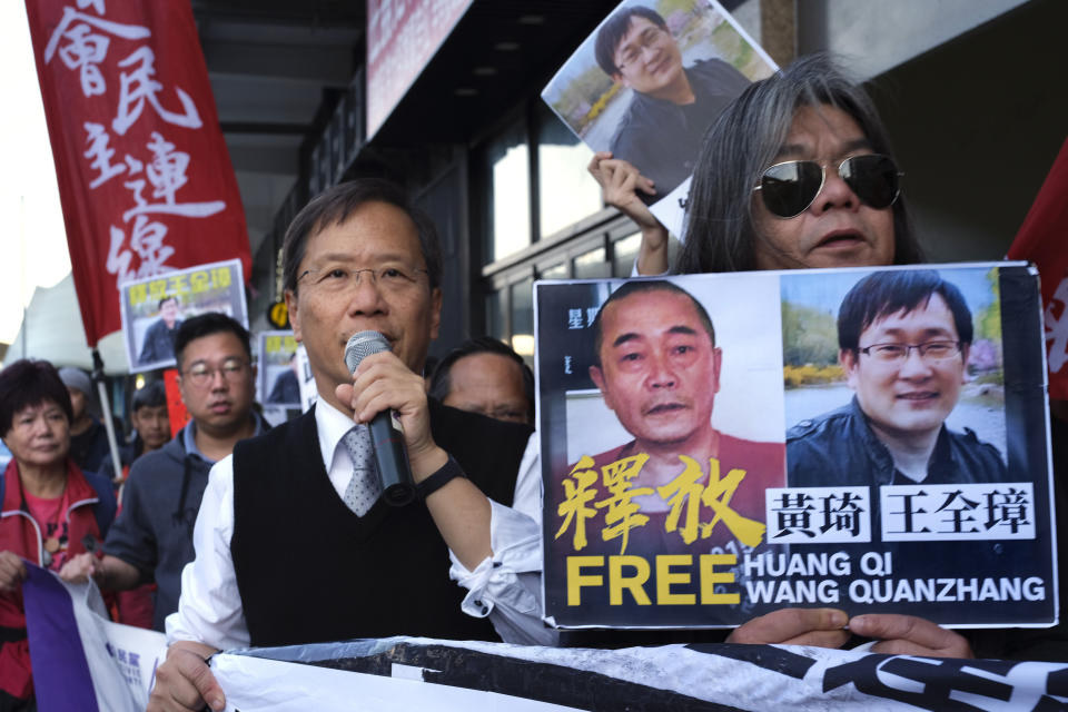 FILE - In this Jan. 29, 2019, file photo, protesters demonstrate in support of prominent Chinese human rights lawyer Wang Quanzhang, right on poster, outside the Chinese liaison office in Hong Kong. Wang was released from prison Sunday, April 5, 2020, after being held for more than four years, his wife Li Wenzu said. Wang was among more than 200 lawyers and legal activists swept up in 2015 in what became known as the 709 Crackdown for the date, July 9, when most of them were detained.(AP Photo/Vincent Yu, File)