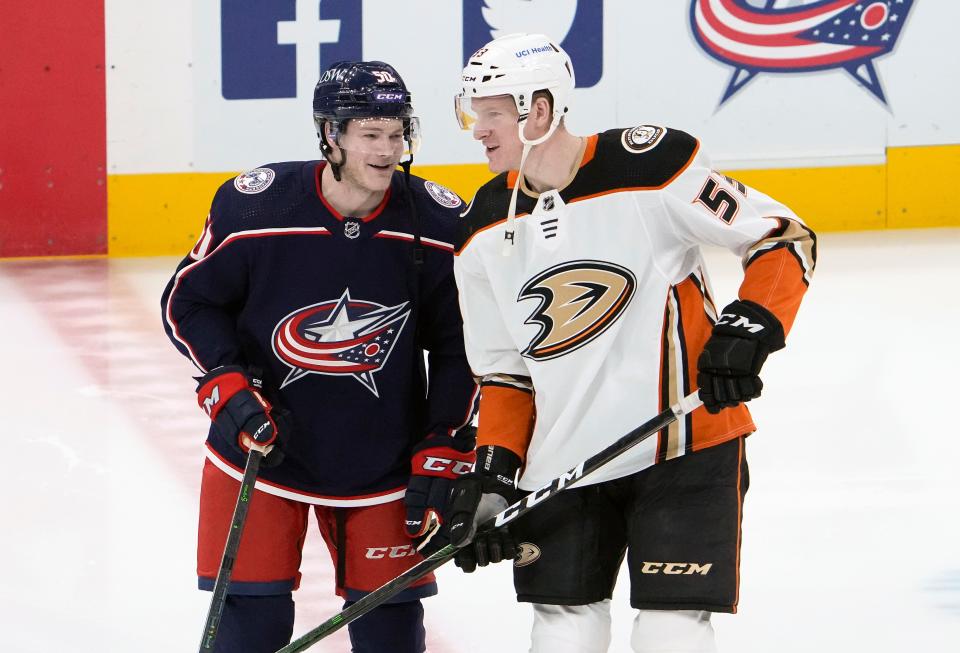 Columbus Blue Jackets left wing Eric Robinson (50) talks to his brother, Anaheim Ducks right wing Buddy Robinson (53), prior to the NHL hockey game at Nationwide Arena in Columbus on Thursday, Dec. 9, 2021.