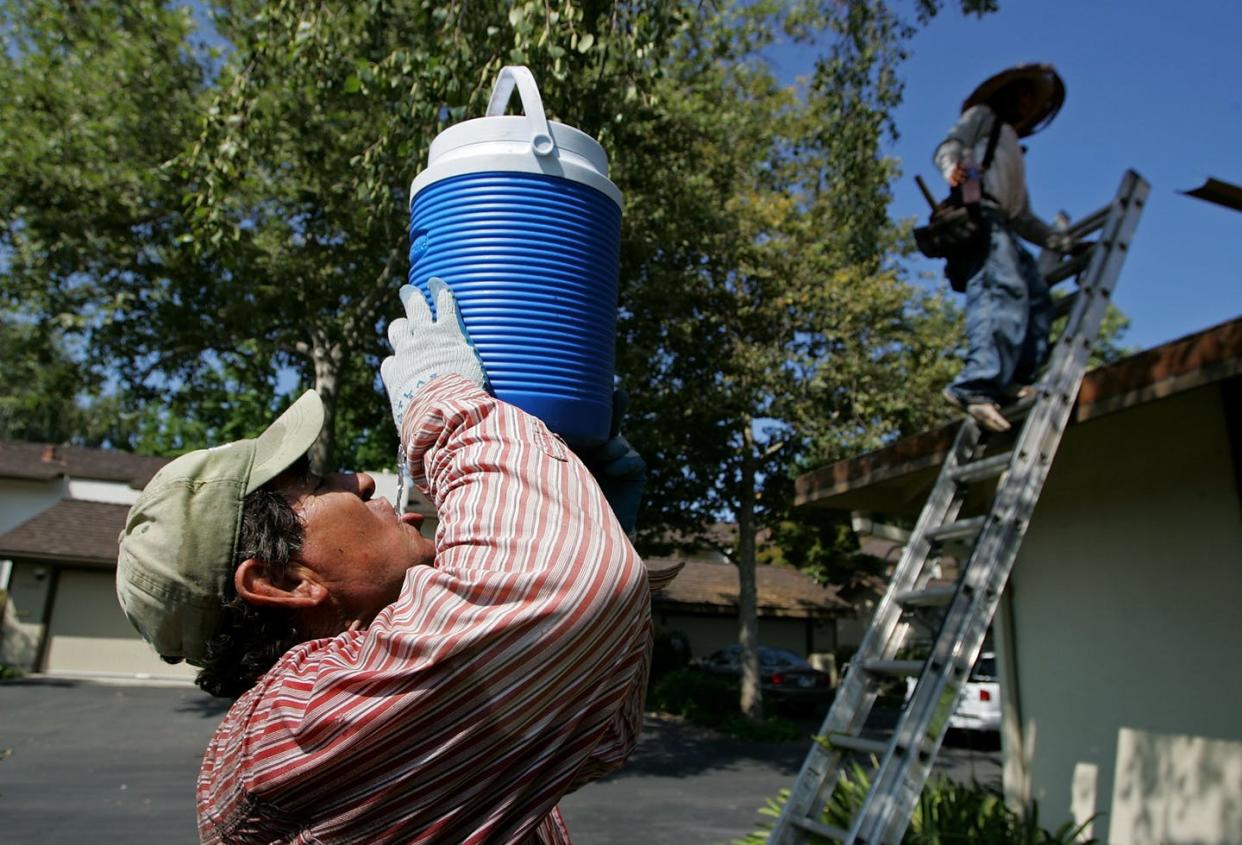 <span class="caption">Constructions workers in warm climates are often exposed to dangerous heat.</span> <span class="attribution"><a class="link " href="https://www.gettyimages.com/detail/news-photo/worker-with-the-moran-roofing-company-takes-a-drink-during-news-photo/71514845?adppopup=true" rel="nofollow noopener" target="_blank" data-ylk="slk:Justin Sullivan/Getty Images;elm:context_link;itc:0;sec:content-canvas">Justin Sullivan/Getty Images</a></span>