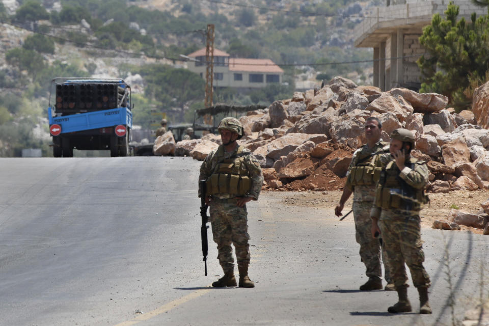 Lebanese army soldiers stand next to a rocket launcher placed on a pick up truck that was used by Hezbollah to fire rockets near Israeli positions, in the southeastern village of Shwaya, near the border with the Golan Heights, Friday, Aug. 6, 2021. The militant Hezbollah group said it fired a barrage of rockets near Israeli positions close to the Lebanese border on Friday, calling it retaliation for Israeli airstrikes on southern Lebanon a day earlier. (AP Photo/Mohammed Zaatari)