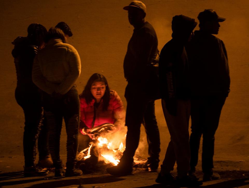 A migrant tries to dry her shoes after crossing the Rio Grande in El Paso, Texas on Dec. 19, 2022, after hearing the U.S. Supreme Court had halted plans to end Title 42.