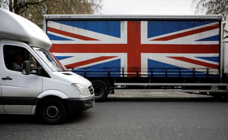 FILE PHOTO: A white van passes a lorry with the Union Flag on the side in London