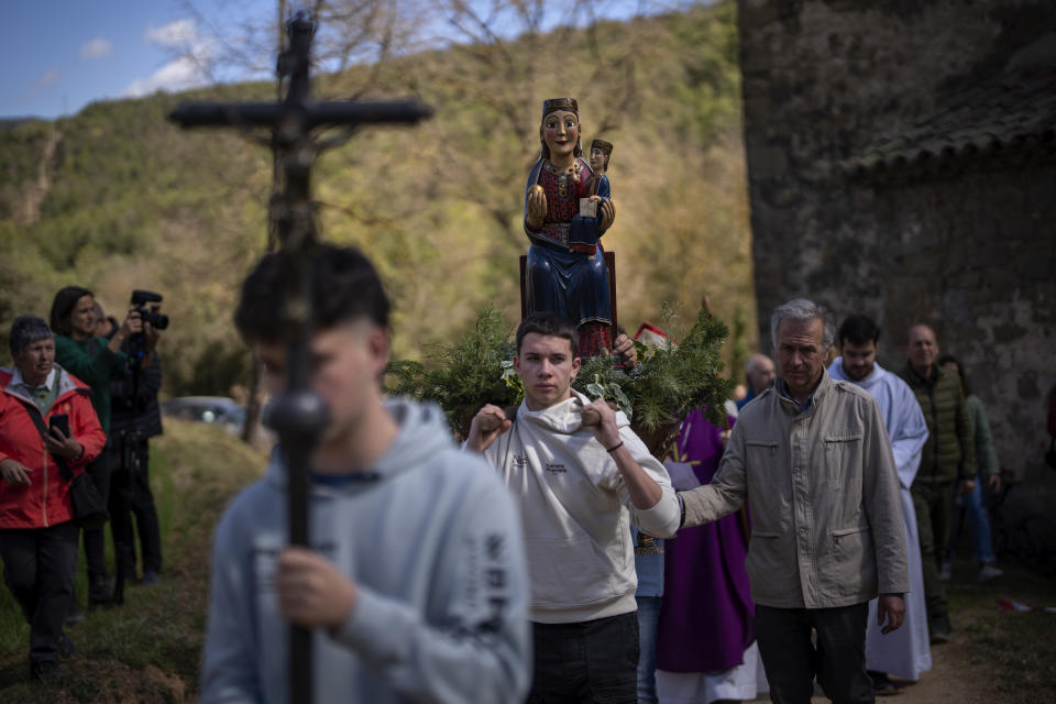 Local residents take part in a procession carrying a statue of the Our Lady of the Torrents, a virgin historically associated with drought, in l'Espunyola, north of Barcelona, Spain, Sunday, March 26, 2023. Farmers and parishioners gathered Sunday at the small hermitage of l'Espunyola, a rural village in Catalonia, to attend a mass asking the local virgin Our Lady of the Torrents for rain. Prayers and hymns were offered to ask for divine intervention in solving the earthly crisis. (AP Photo/Emilio Morenatti)