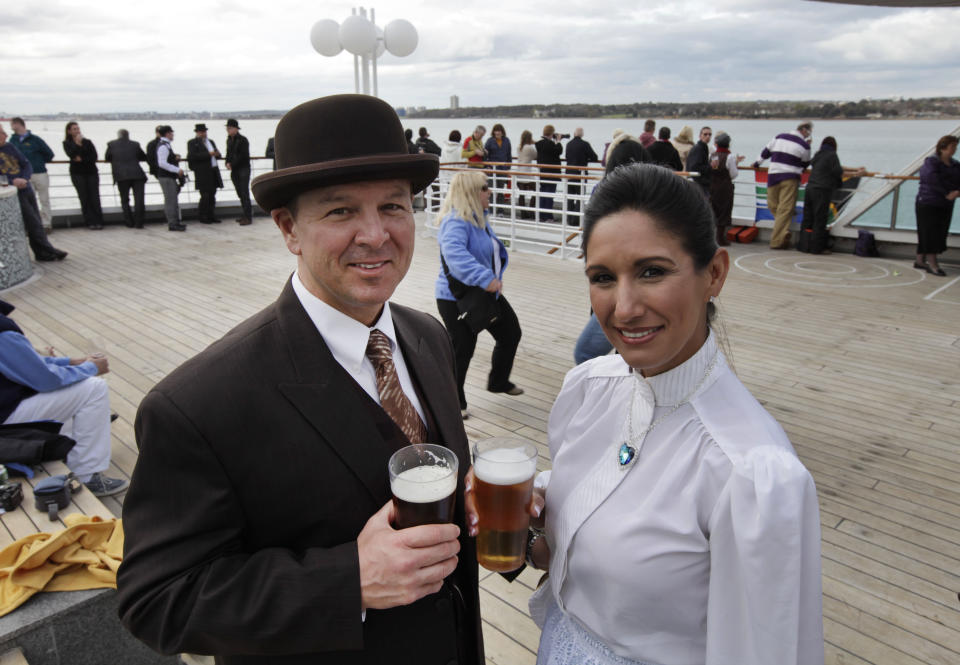 Passengers wearing costumes pose for pictures as the MS Balmoral Titanic memorial cruise ship sail from Southampton, England, on Easter Sunday, April 8, 2012. Nearly 100 years after the Titanic went down, a cruise with the same number of passengers aboard is setting sail to retrace the ship's voyage, including a visit to the location where it sank. The Titanic Memorial Cruise departed Sunday from Southampton, where the Titanic left on its maiden voyage and the 12-night cruise will commemorate the 100th anniversary of the sinking of the White Star liner. With 1,309 passengers aboard, the MS Balmoral will follow the same route as the Titanic and organizers are trying to recreate the onboard experience minus the disaster from the food to a band playing music from that era. (AP Photo/Lefteris Pitarakis)