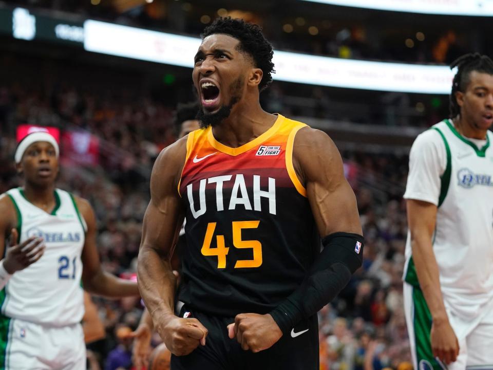 Donovan Mitchell flexes and yells after a basket during a game.